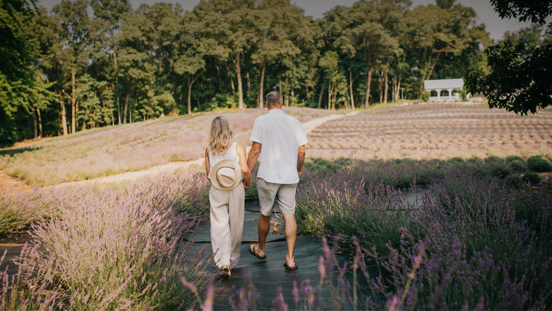 Couple walking between blooming lavender rows at golden hour near Fort Wayne, Indiana