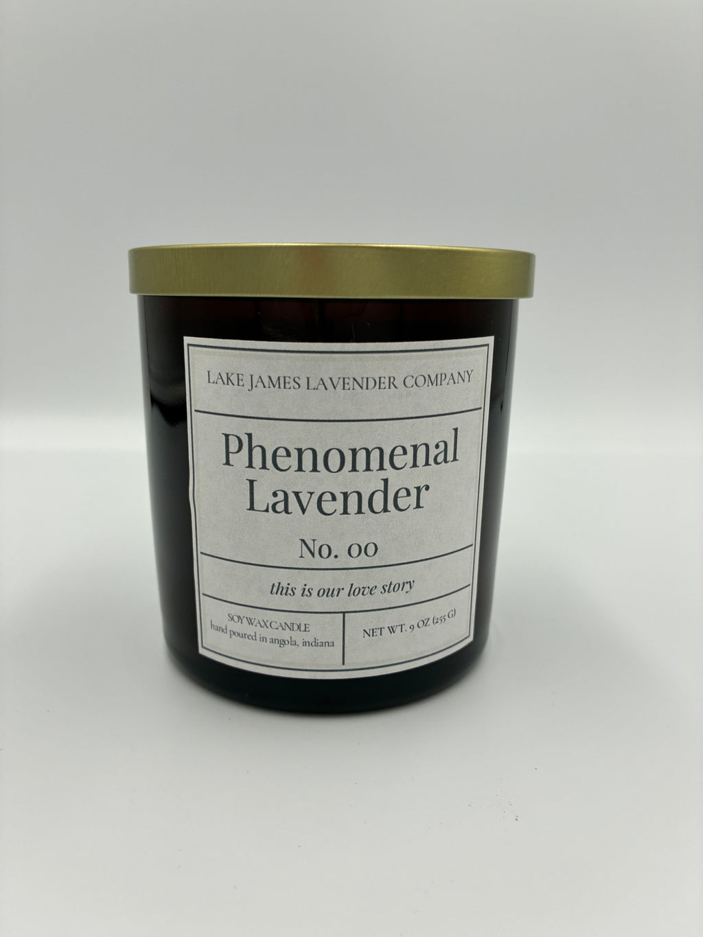 Black candle with gold lid and white label on a white background