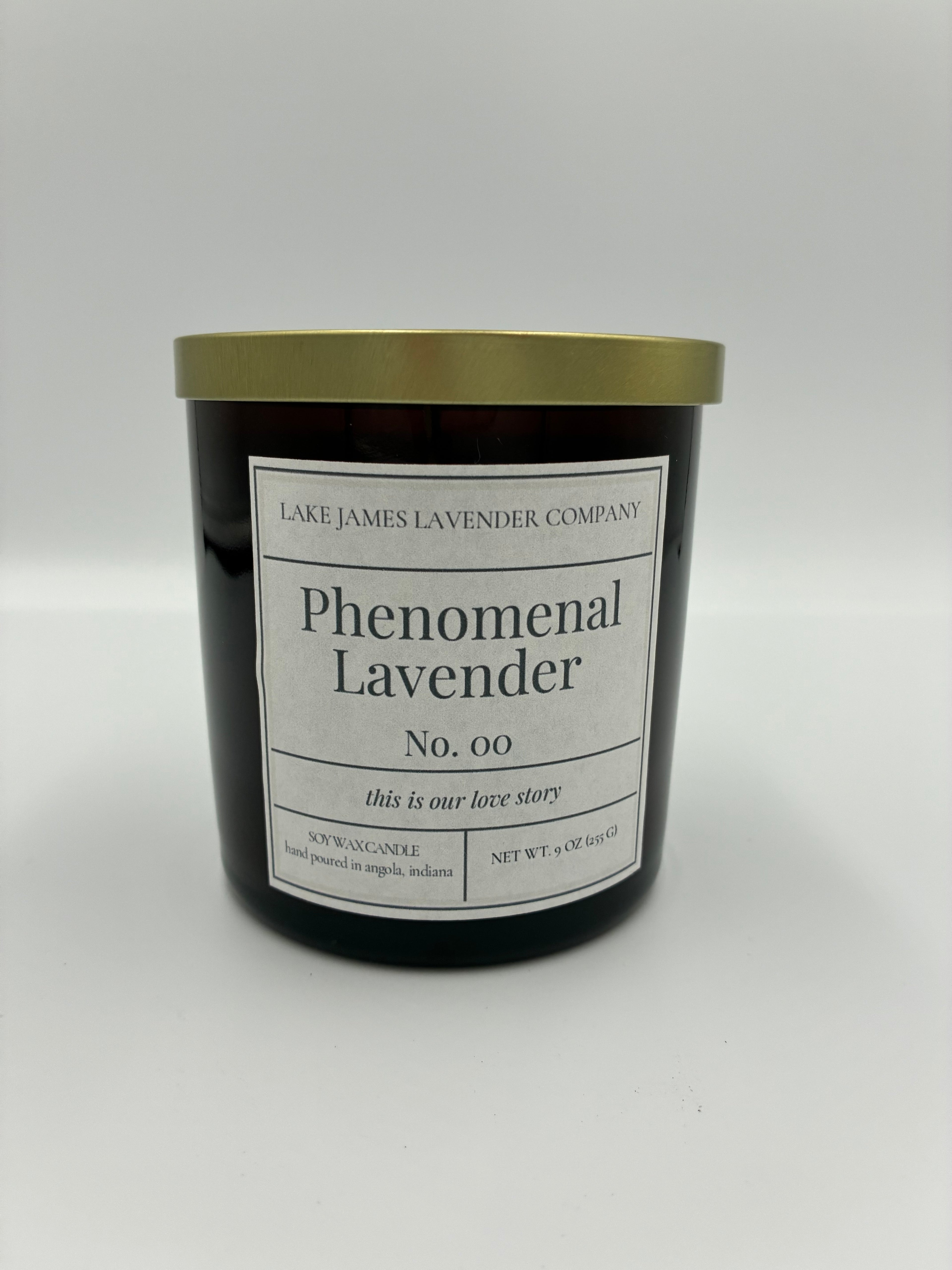 Black candle with gold lid and white label on a white background