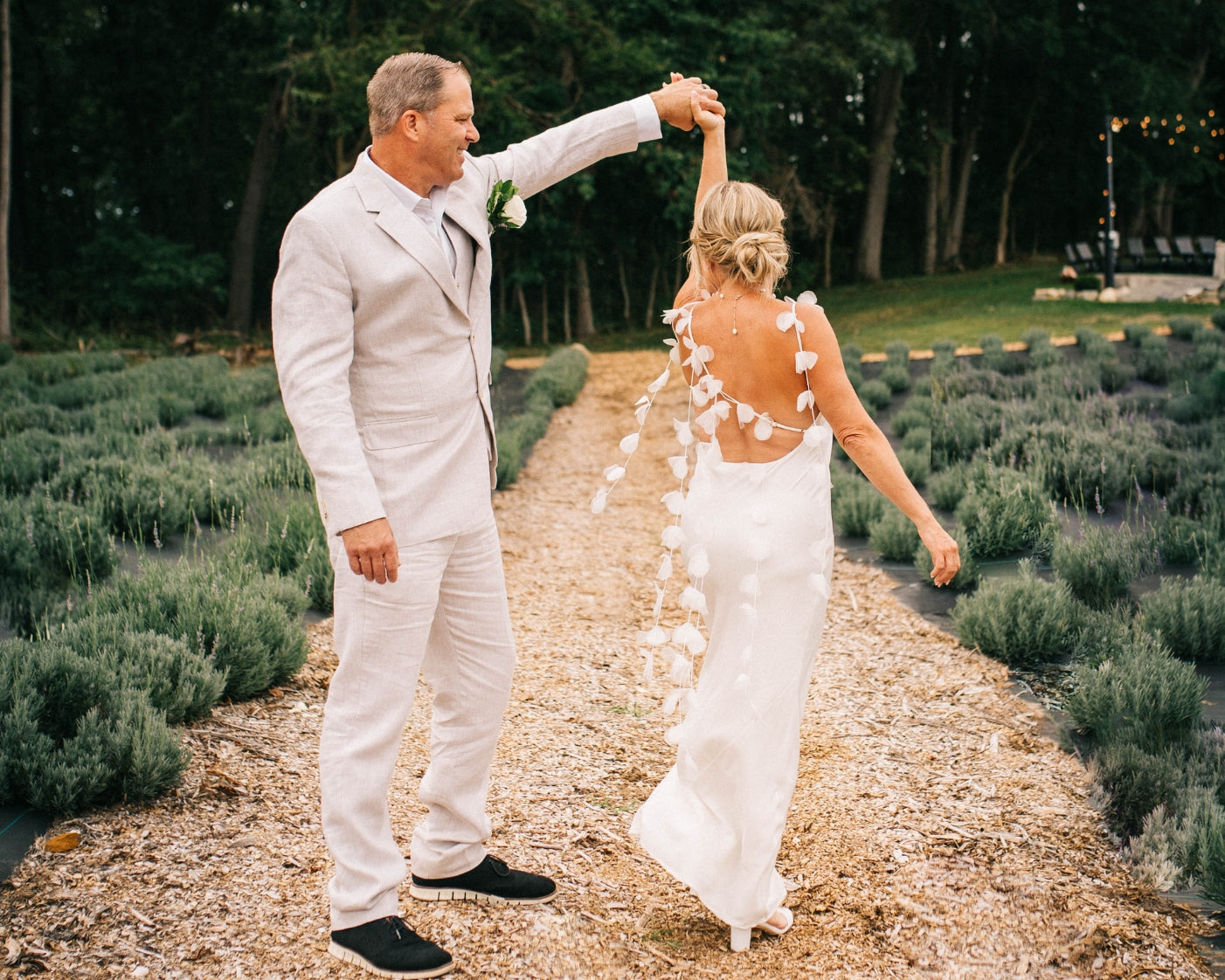 Bride and groom dancing between lavender rows at their wedding at Lake James Lavender Company in Angola, Indiana