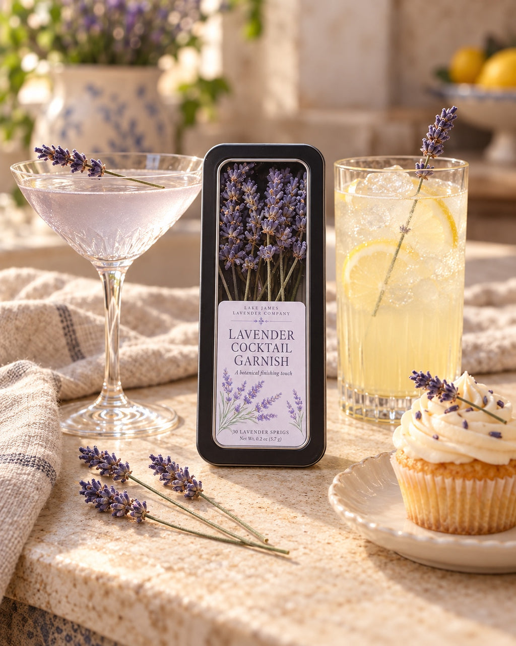 Lake James Lavender Company Lavender Cocktail Garnish tin with a lavender cocktail, lemonade, cupcake, and loose lavender sprigs.